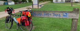 Bicycle parked in front of riding trail sign