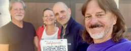 Group of people posing with a license plate that says Warmshowers
