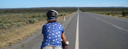 woman riding a bicycle on a deserted road