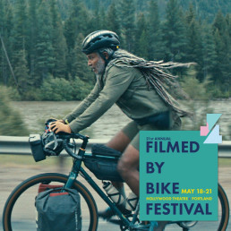 Man riding a bicycle with wording: Filmed by Bike Festival
