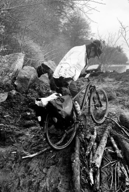 Bike Rider Carrying Bicycle over Rocks and Logs