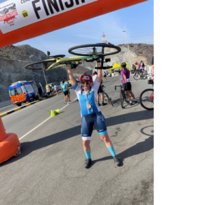 Cyclist posing with bike overhead at the finish line