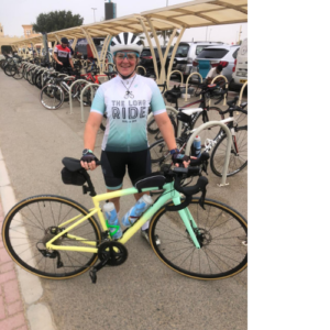 Cyclist posing with pastel bike at bike rack