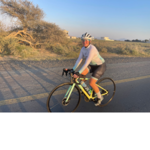 Cyclist riding pastel bike on open road