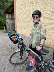 A person posing with their bicycle