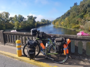 A loaded touring bicycle on a bridge over a river